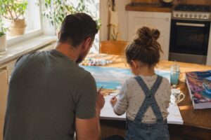 Vater und Kind beim Malen nach Zahlen